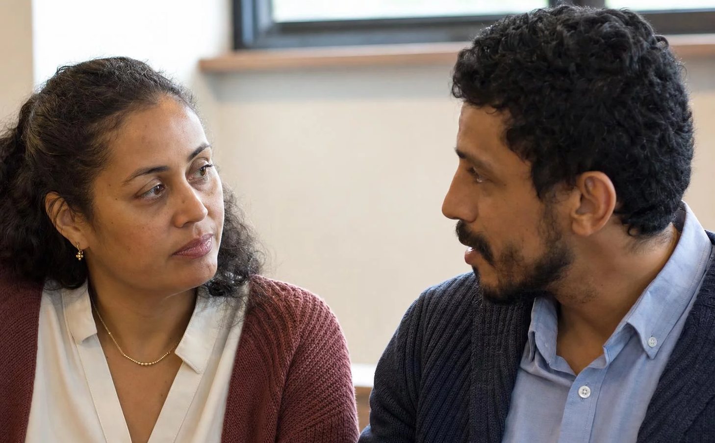 Duas pessoas frente a frente na mesa: uma sustenta a fala, a outra anota o que ouviu